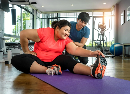 Bariatric patient stretching in gym
